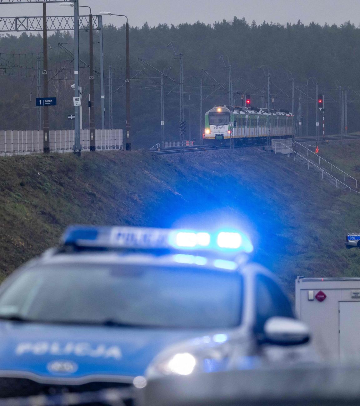 Ein Polizeiwagen ist sichtbar, welcher in der Nähe zu den Bahngleisen steht, auf denen ein Sprengstoff explodiert ist.