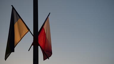 Flaggen Polens und der Ukraine bei Dämmerung an einem Mast