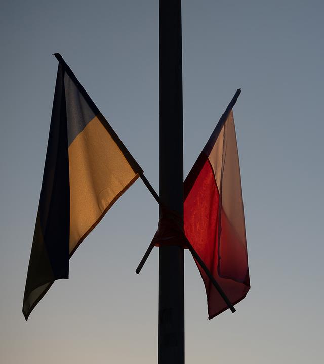 Flaggen Polens und der Ukraine bei Dämmerung an einem Mast