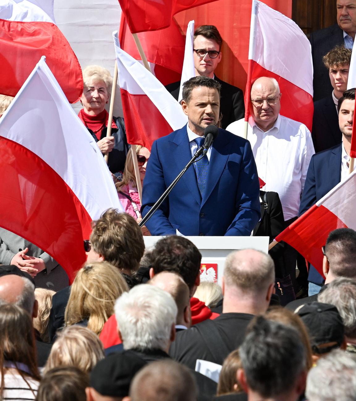 Rafal Trzaskowski hält im Wahlkampf für die Präsidentschaftswahlen in Polen eine Rede. Um ihn herum sind Menschen versammelt, die polnische Flaggen halten.