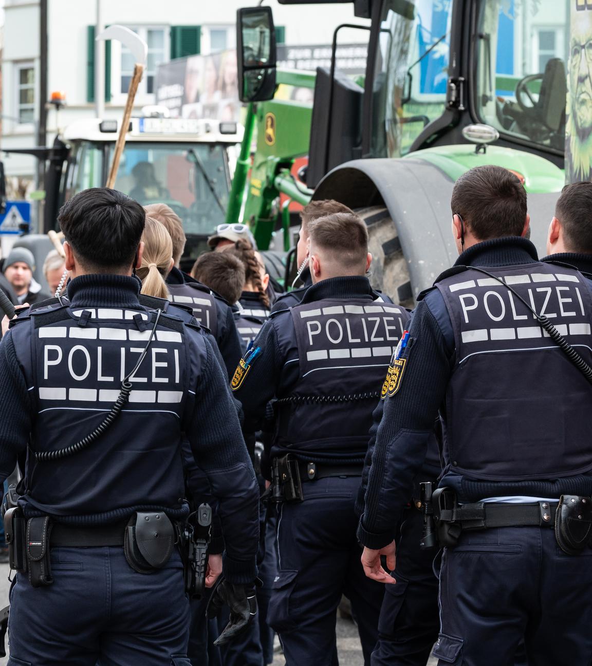 Baden-Württemberg, Biberach an der Riß: Polizisten gehen während einer Demonstration vor Beginn des politischen Aschermittwochs der baden-württembergischen Grünen vor der Stadthalle in Biberach an der Riß.