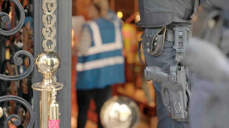 Polizist vor einer Shisha-Bar "Kriminelle Clans in Deutschland - Ist der Staat machtlos?": Ein Pistolenhalfter ist an der Hüfte eines Polizisten befestigt.