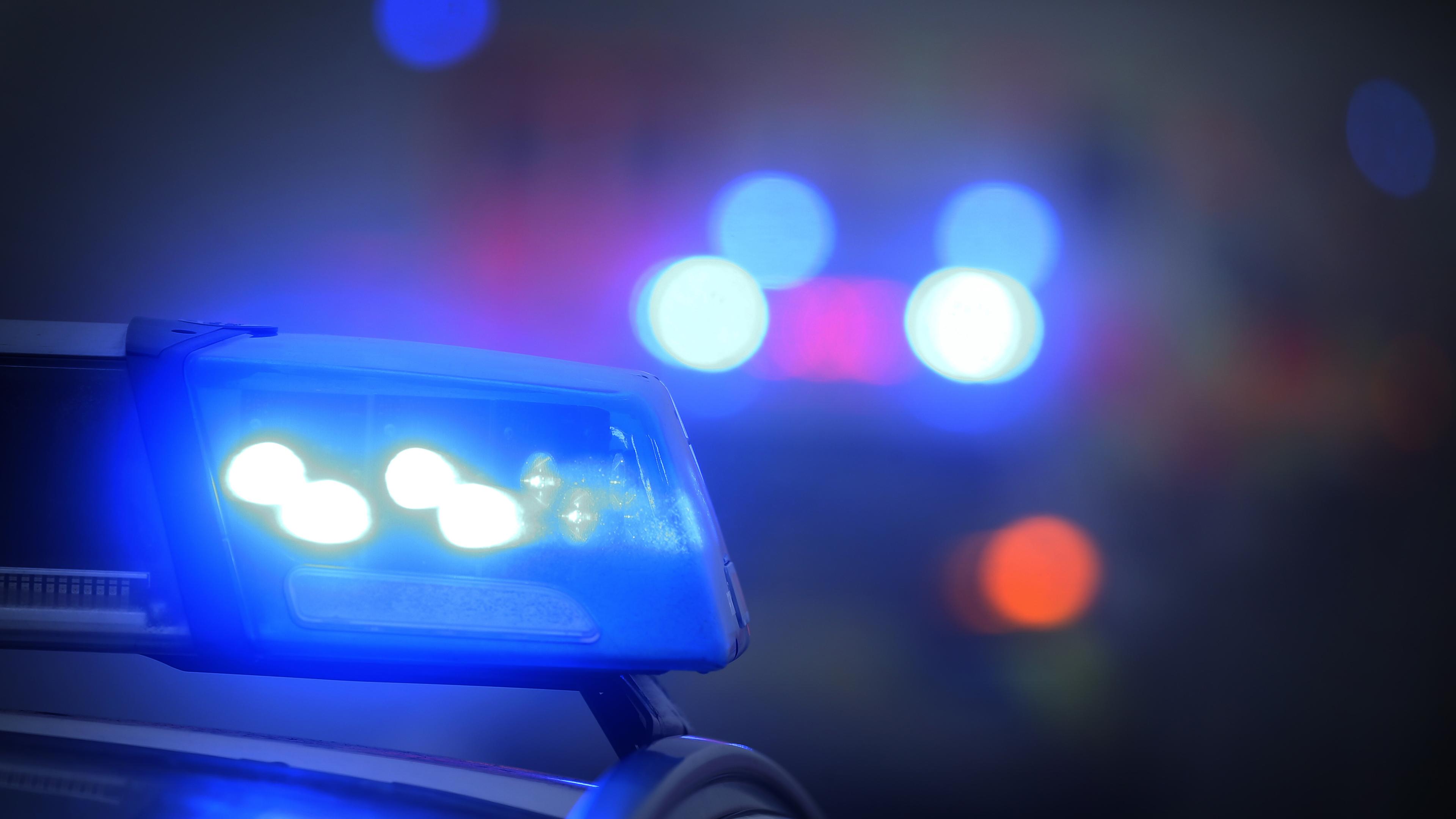 Ein Polizeiauto mit eingeschaltetem Blaulicht steht an einer Unfallstelle. (Symbolbild)
