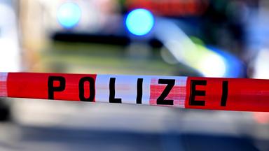 Ein Flatterband mit der Aufschrift "Polizei" weht im Wind.