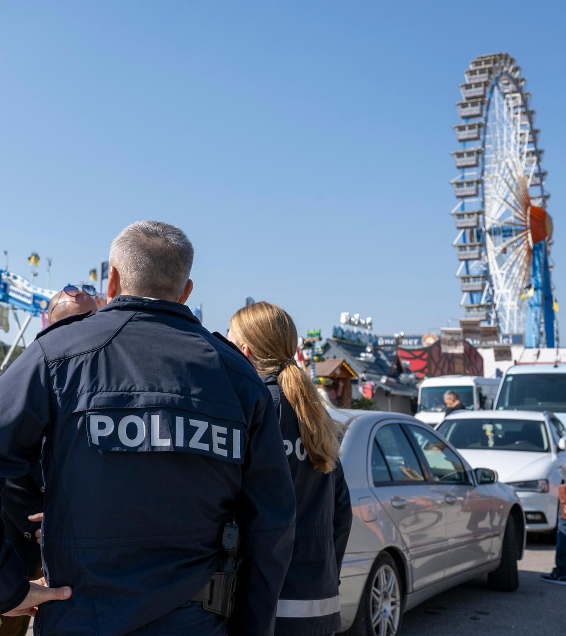Polzei auf einem Volksfest. Im Hintergrund steht ein Riesenrad.