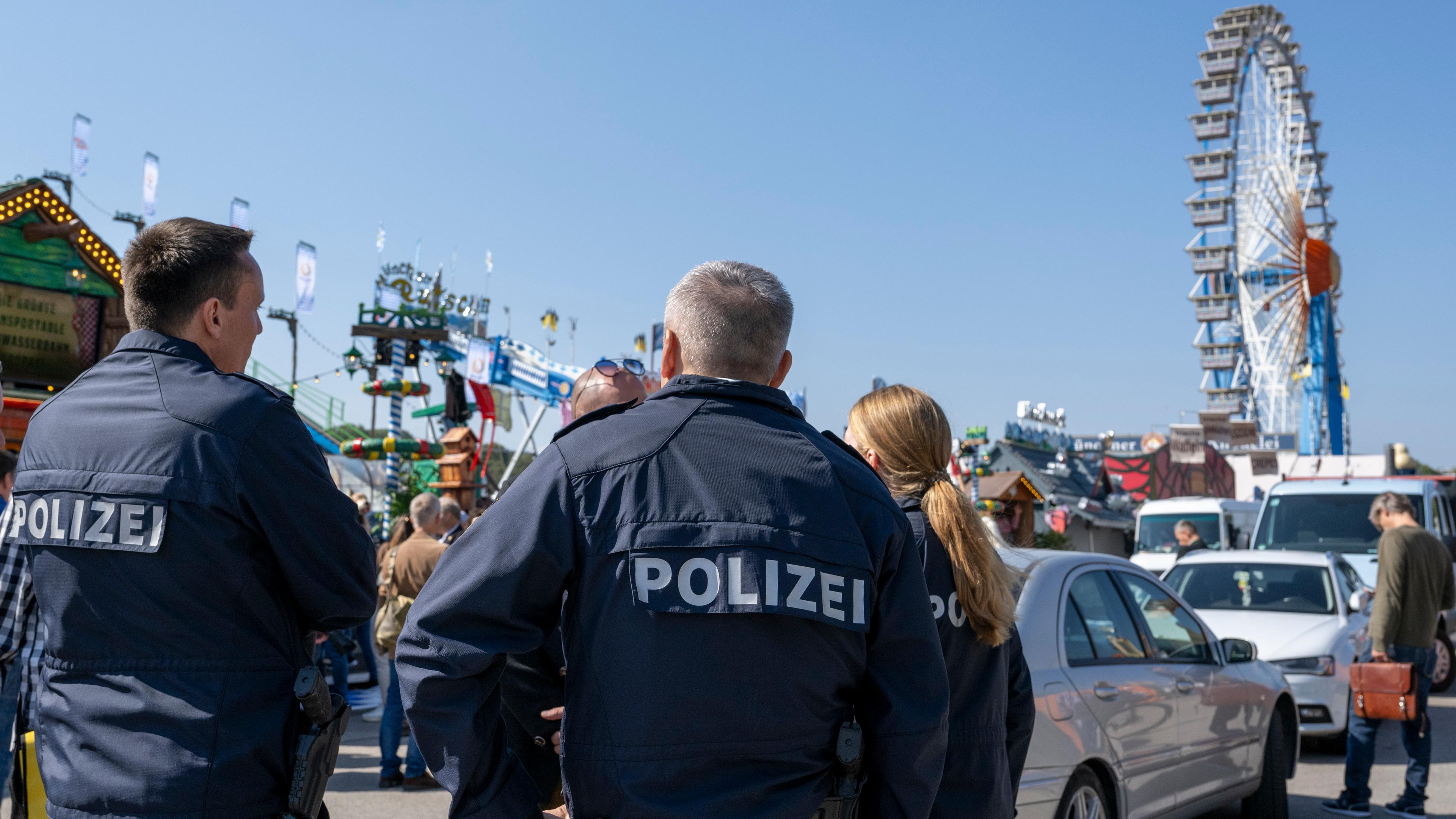 Polzei auf einem Volksfest. Im Hintergrund steht ein Riesenrad.