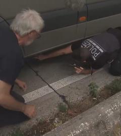 Ein Polizist inspiziert einen Wohnwagen von unten