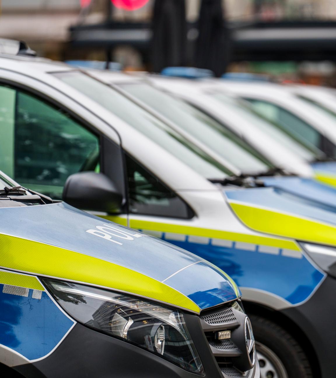 Einsatzfahrzeuge der Polizei stehen vor dem ersten Polizeirevier. 