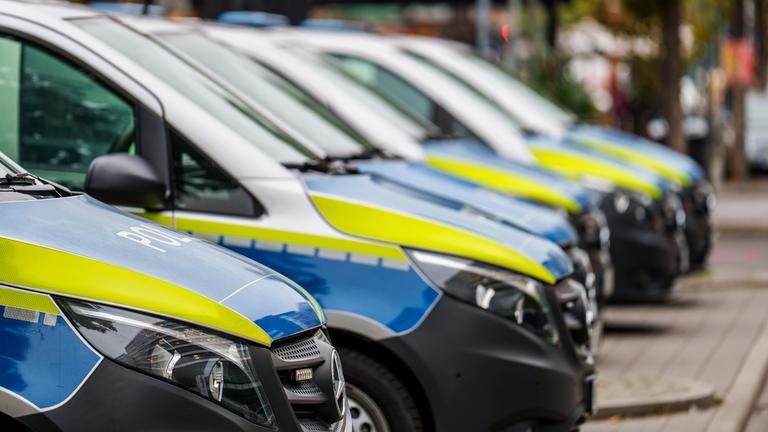 Einsatzfahrzeuge der Polizei stehen vor dem ersten Polizeirevier. 