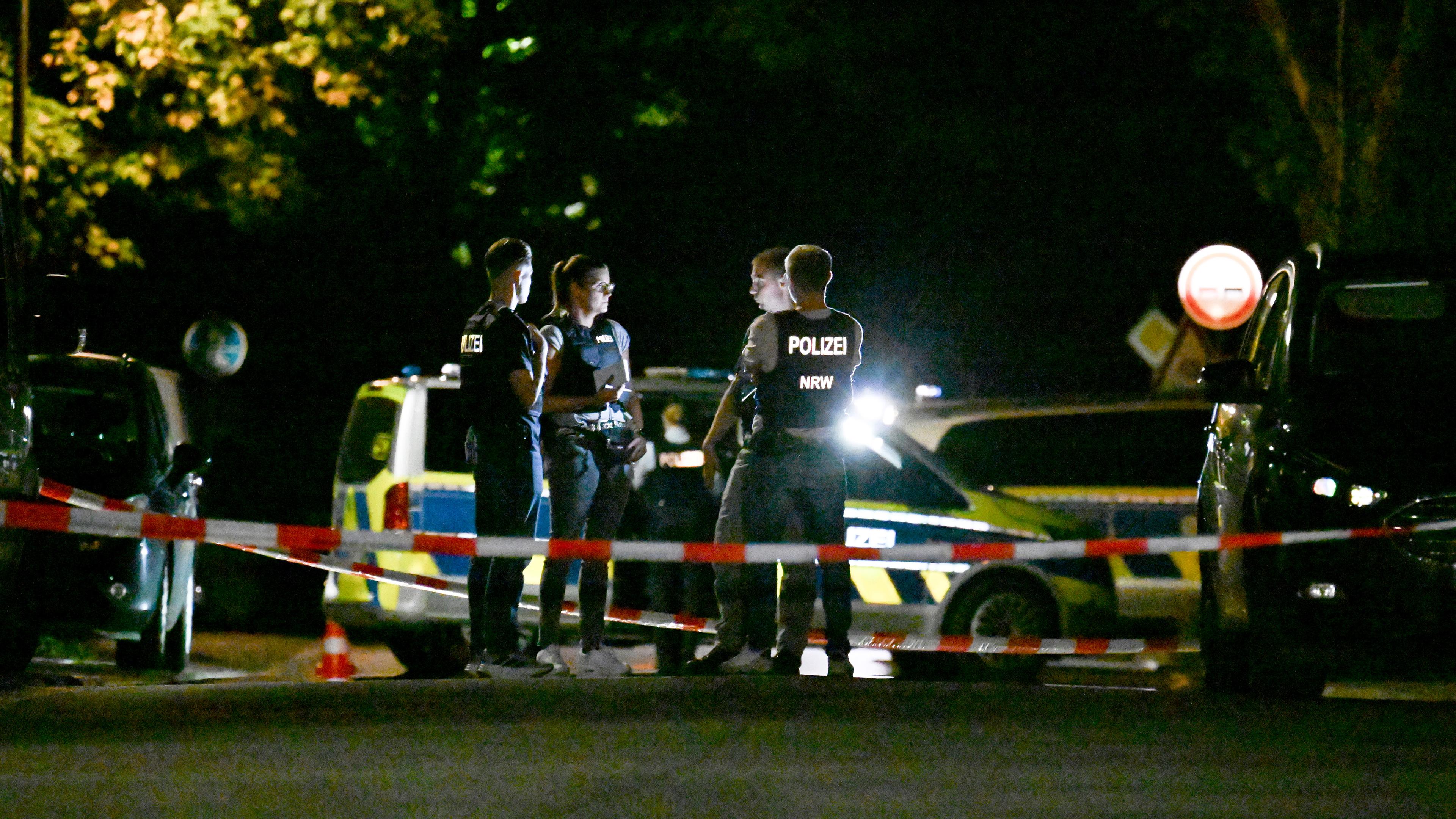 Polizisten stehen auf einer abgesperrten Straße. Bei einem Schusswaffeneinsatz der Polizei in Recklinghausen ist ein mutmaßlicher Messerangreifer tödlich getroffen worden. 