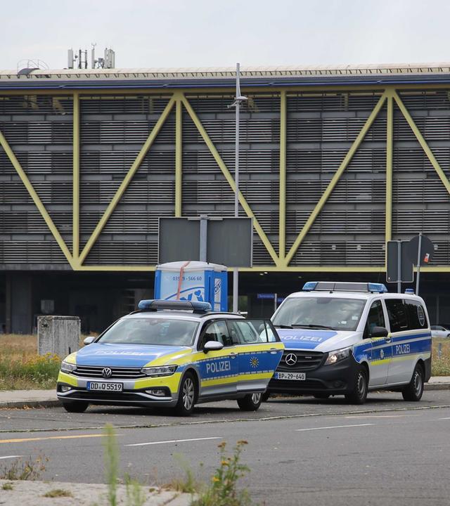 Zwei Einsatzfahrzeuge der Polizei stehen beim Flughafen Leipzig/Halle. 