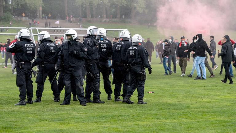 Polizisten und Fans des 1. FC Köln auf der Jahnwiese vor dem Stadion