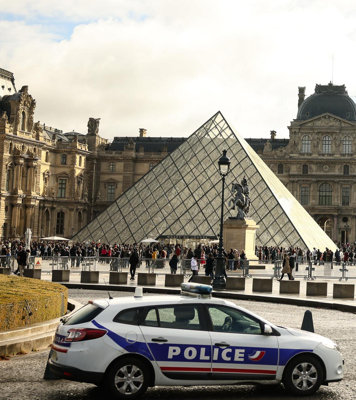 Ein Polizeiwagen steht vor dem Louvre