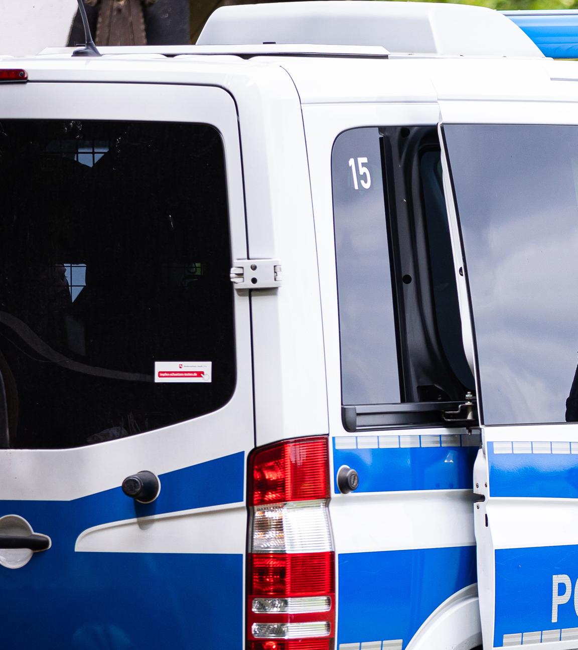 Ein Polizist steht an einem Einsatzfahrzeug (Archivfoto)