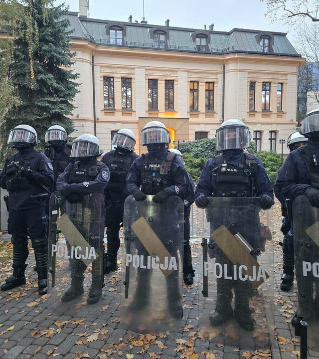 Mehrere polnische Polizisten stehen auf dem Gelände des polnischen Verfassungsgerichts in Warschau. Im Hintergrund ist das Verfassungsgericht zu sehen.