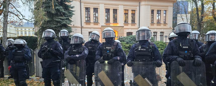 Mehrere polnische Polizisten stehen auf dem Gelände des polnischen Verfassungsgerichts in Warschau. Im Hintergrund ist das Verfassungsgericht zu sehen.