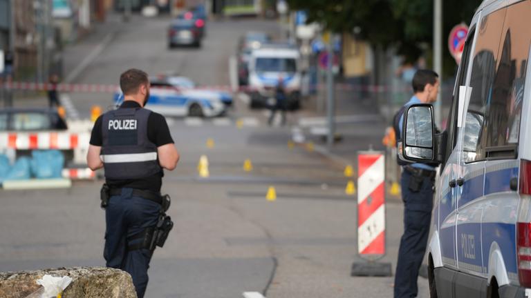 Polizeibeamte untersuchen das Umfeld eines Tatorts. Nach einem Raubüberfall auf eine Tankstelle im saarländischen Völklingen ist ein Polizist durch Schüsse getötet worden.