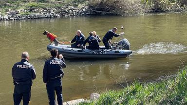 Polizisten suchen ein Gewässer nach einem vermissten Jungen in Hessen ab.