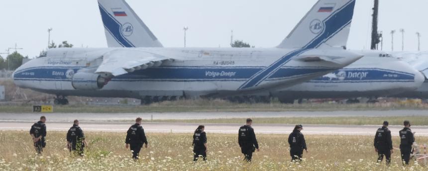 Polizisten gehen über eine Wiese auf dem Gelände des Flughafen-Leipzig. 