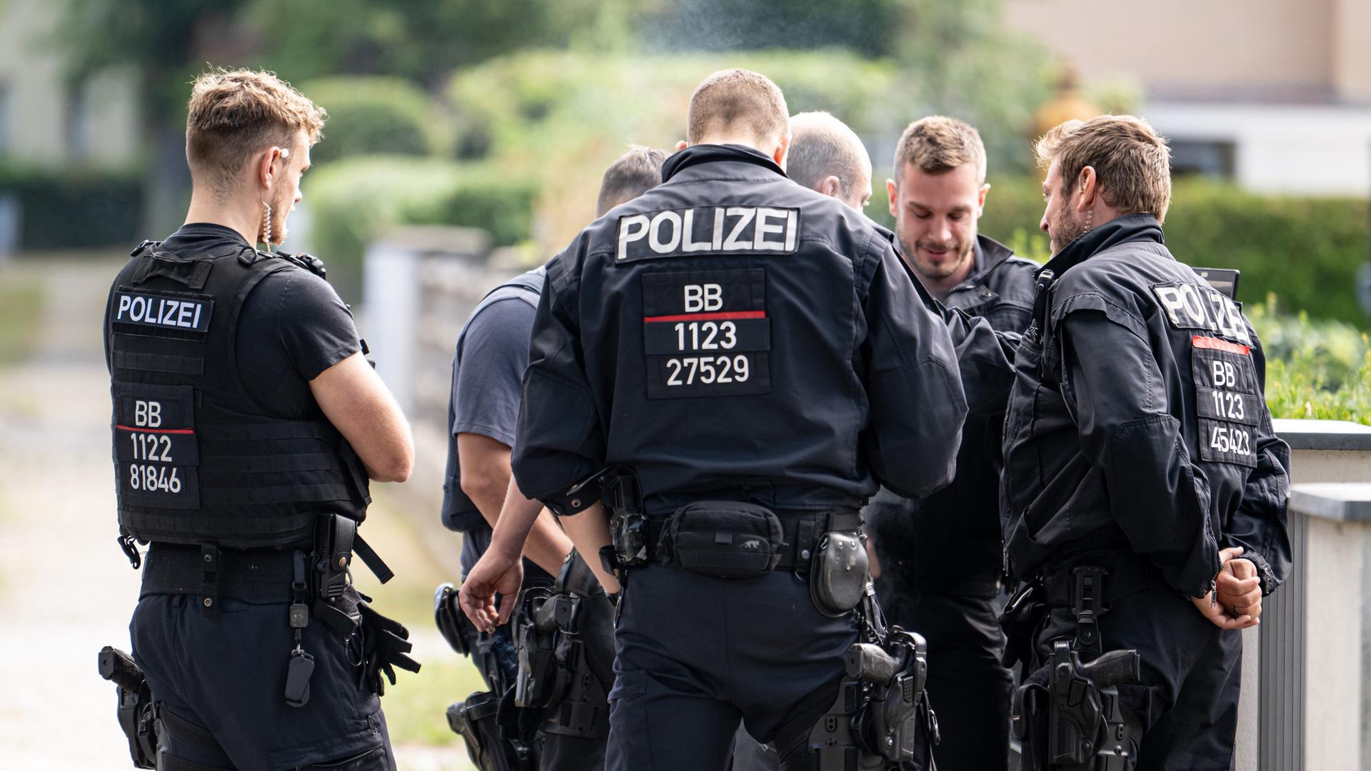 Polizisten koordinieren die Such in einem Wohngebiet in Teltow nach einem Wildtier. 