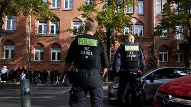 Polizisten stehen vor dem Ernst-Abbe-Gymnasium in der Sonnenallee im Berliner Stadtteil Neukölln.