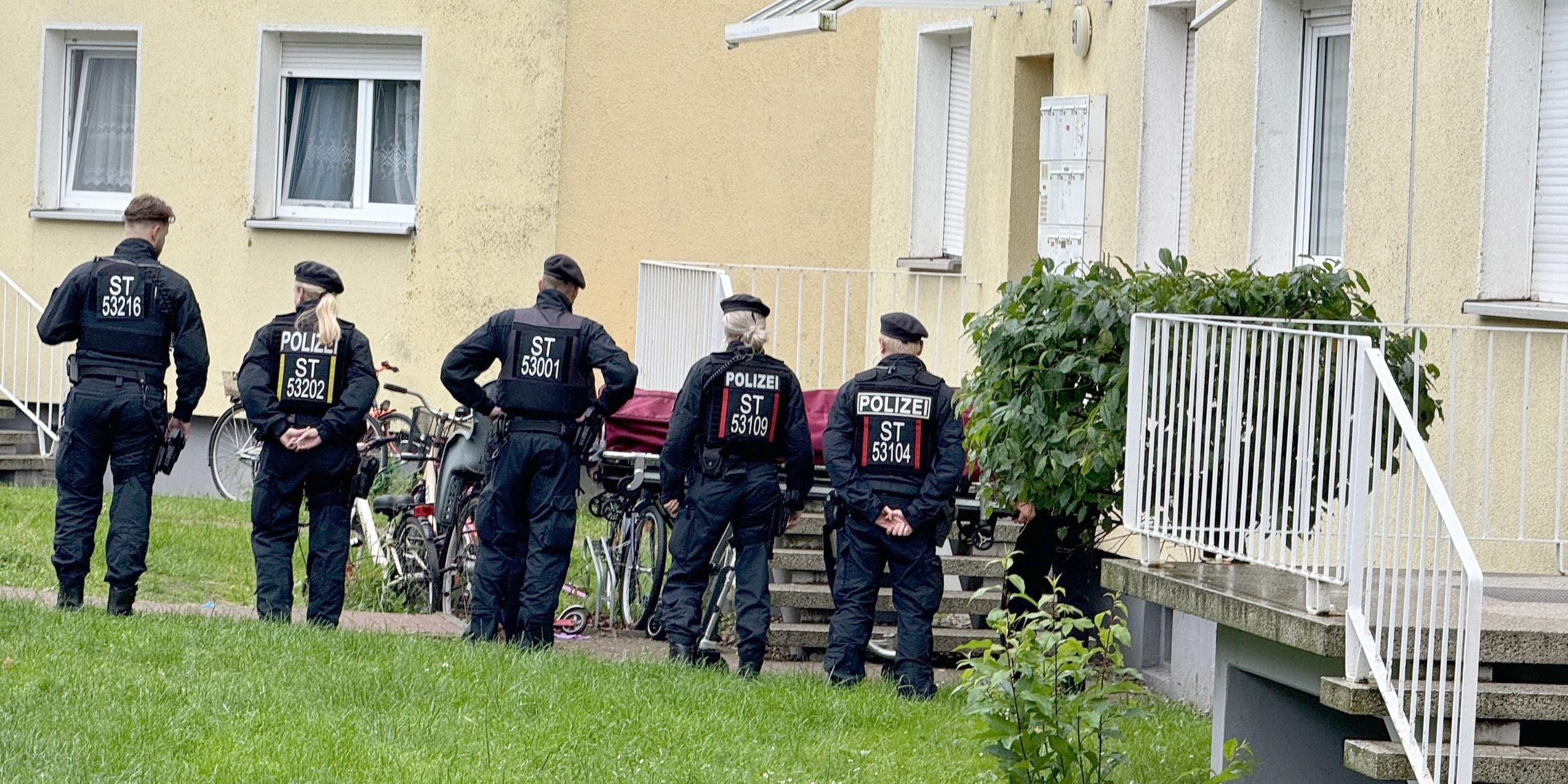 Polizisten stehen an einem Einsatzort, der möglichwerweise im Zusammenhang mit der Attacke in Wolmirstedt steht