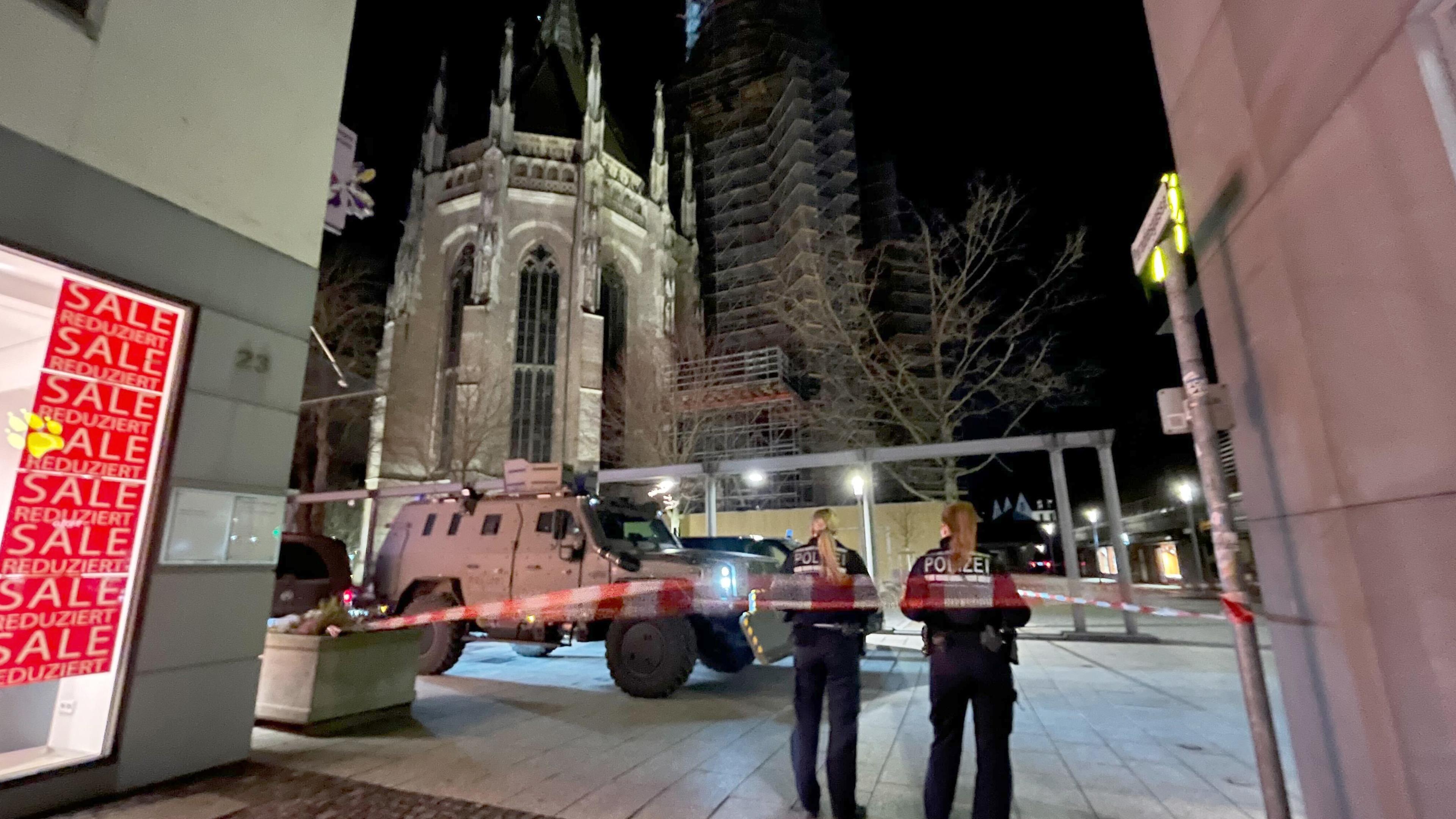 Zwei Polizistinnen stehen hinter einem Absperrband der Polizei am Münsterplatz.