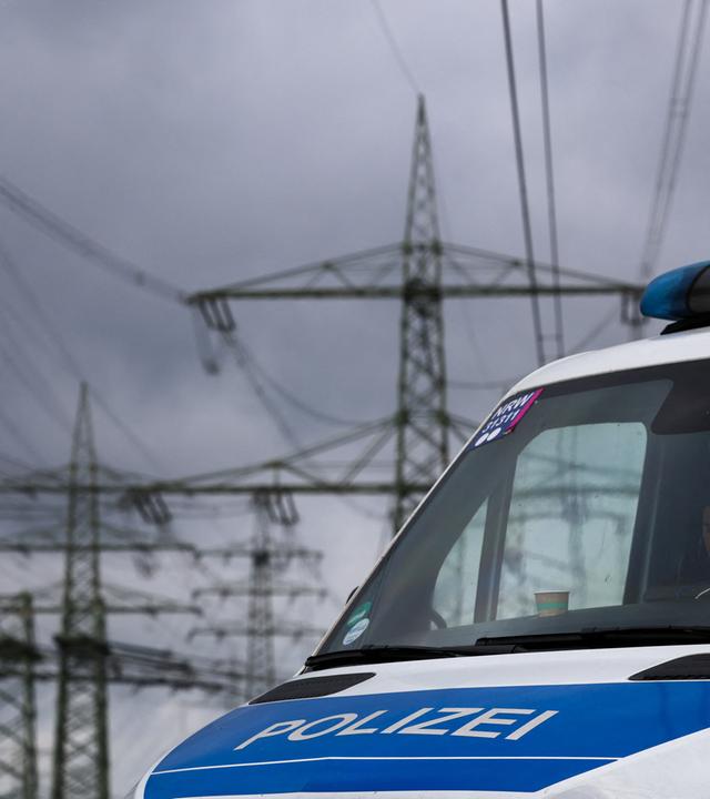 Polizeifahrzeuge stehen in der Nähe des RWE-Kraftwerkes Eschweiler an einem Umspannwerk. 