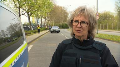 Polizeipfarrerin Astrid Stephan steht neben einem Polizeiauto