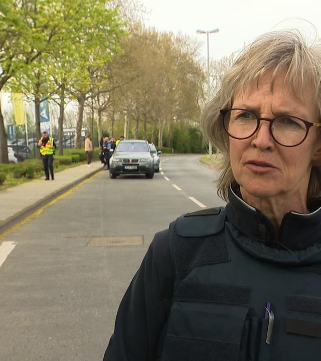 Polizeipfarrerin Astrid Stephan steht neben einem Polizeiauto
