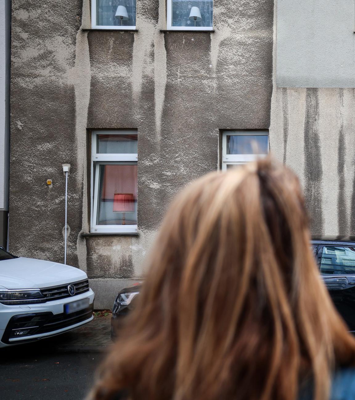 Eine Frau steht vor einem Mehrfamilienhaus in Bochum, aufgenommen am 17.11.2025