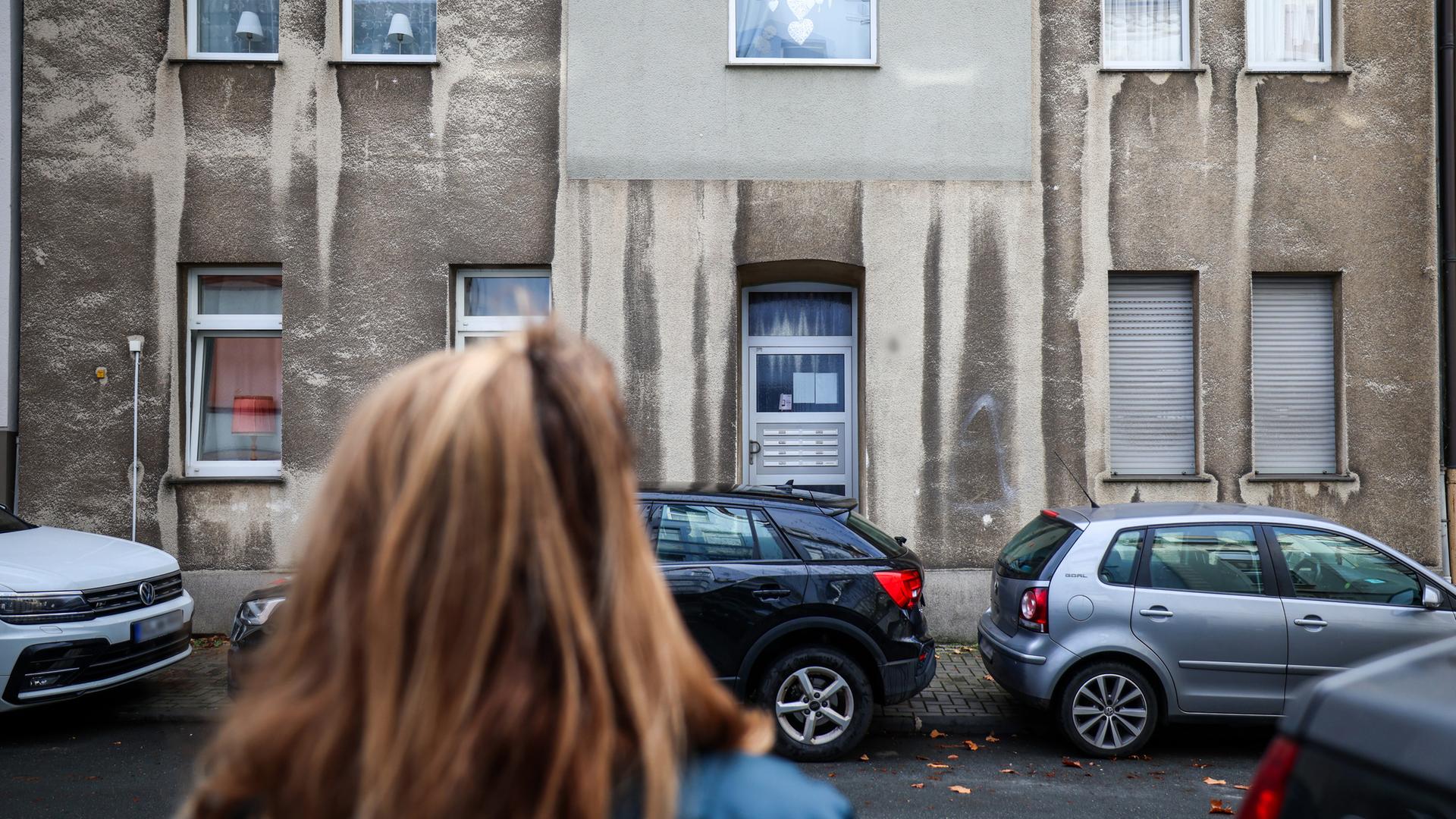 Eine Frau steht vor einem Mehrfamilienhaus in Bochum, aufgenommen am 17.11.2025