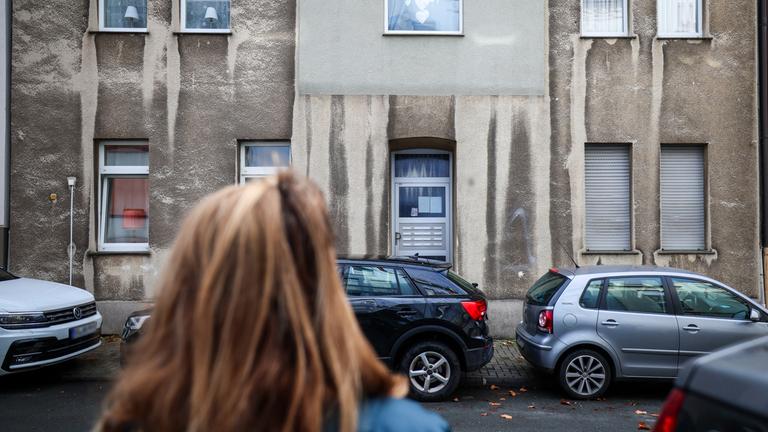 Eine Frau steht vor einem Mehrfamilienhaus in Bochum, aufgenommen am 17.11.2025