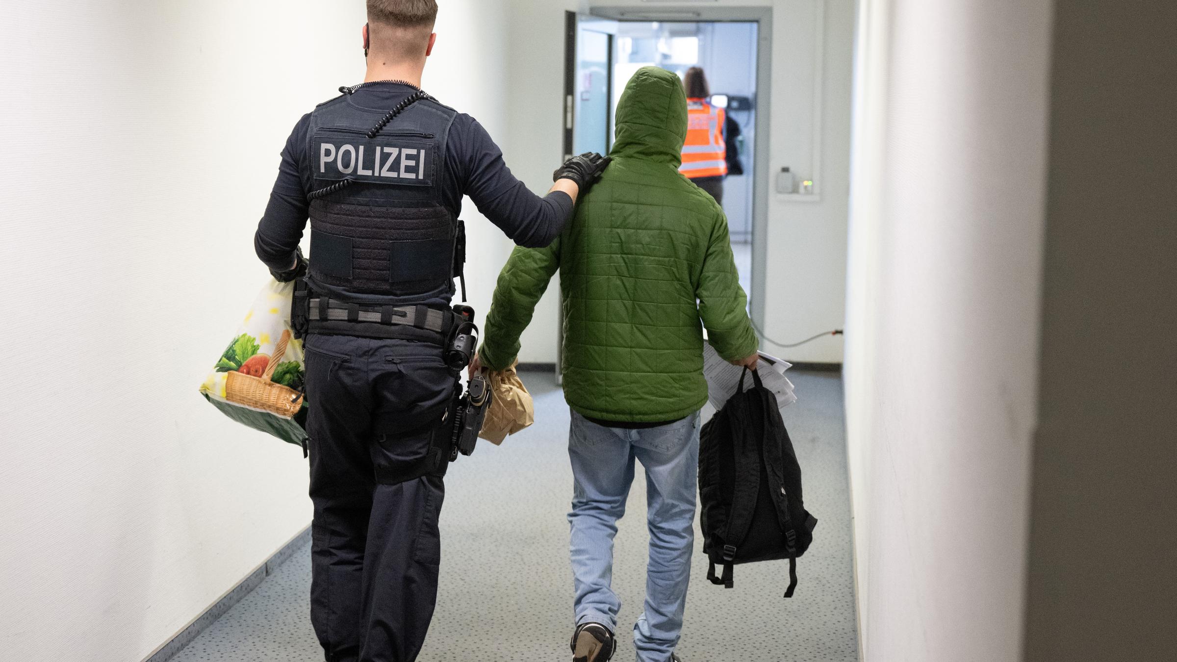 Polizist führt Mann zum Abschiebeflug, Archivbild