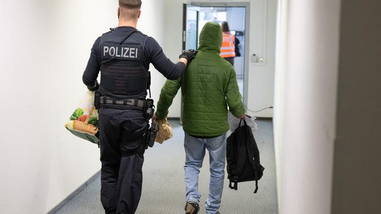 Polizist führt Mann zum Abschiebeflug, Archivbild
