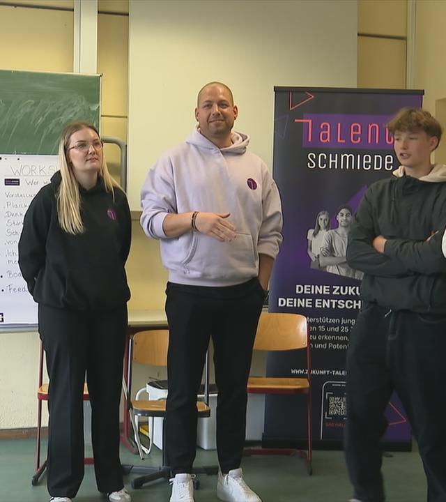 Polizist mit Jugendlichen bei Workshop an Schule.