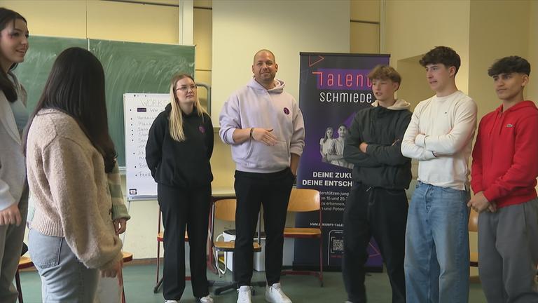 Polizist mit Jugendlichen bei Workshop an Schule.