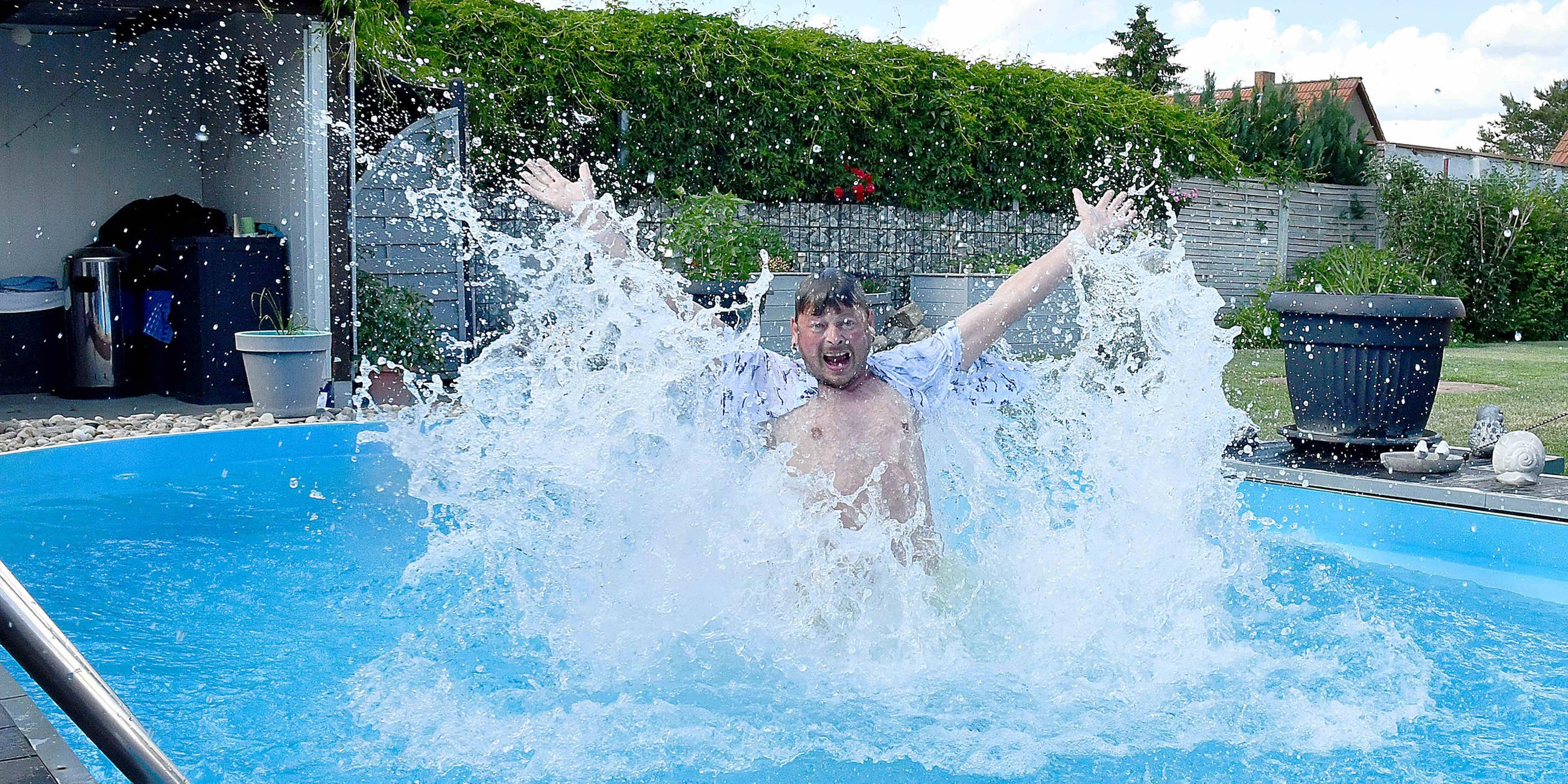 ,Mann springt in Wasser seines Swimming Pools