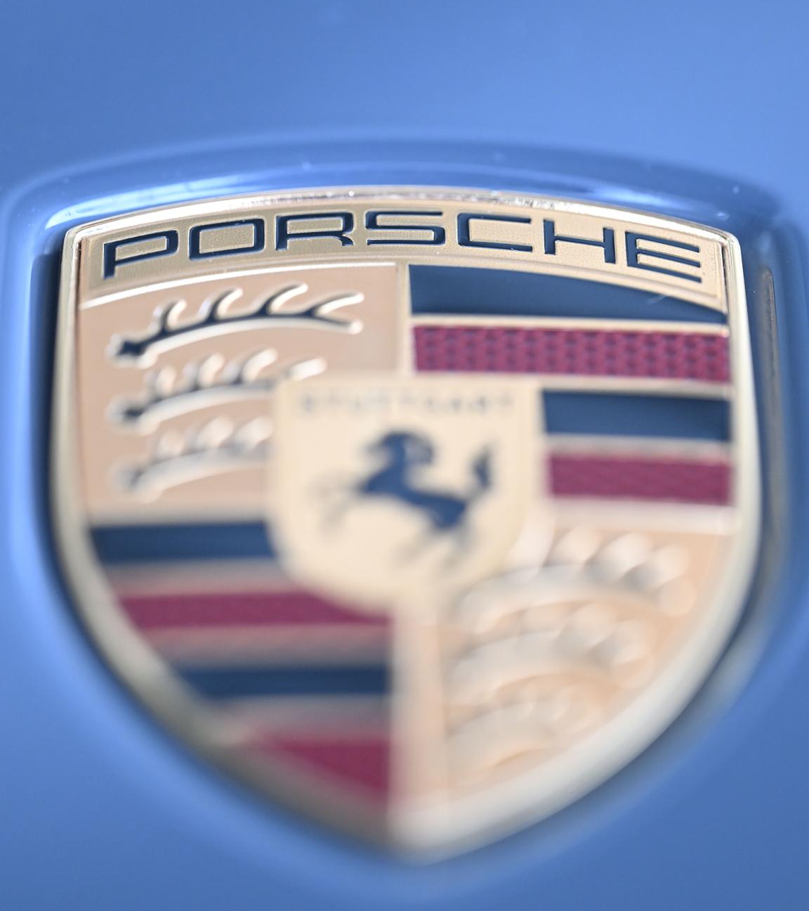 10.10.2025, Baden-Württemberg, Stuttgart: Das Logo des Stuttgarter Sportwagenbauers Porsche an einem Sportwagen der Marke.