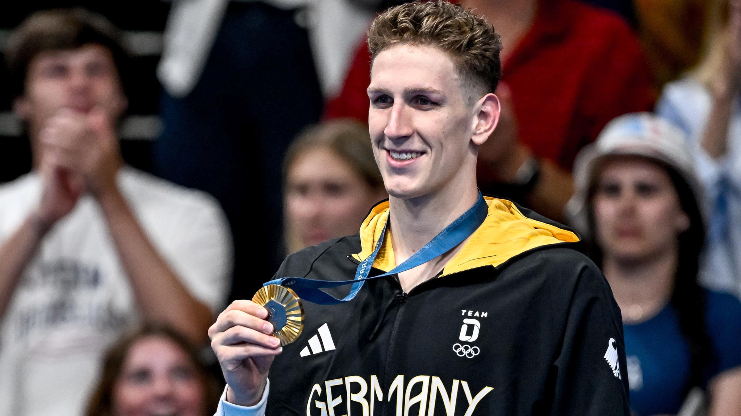 Lukas Märtens aus Deutschland zeigt die Goldmedaille nach dem 400-m-Freistil-Finale der Männer.
