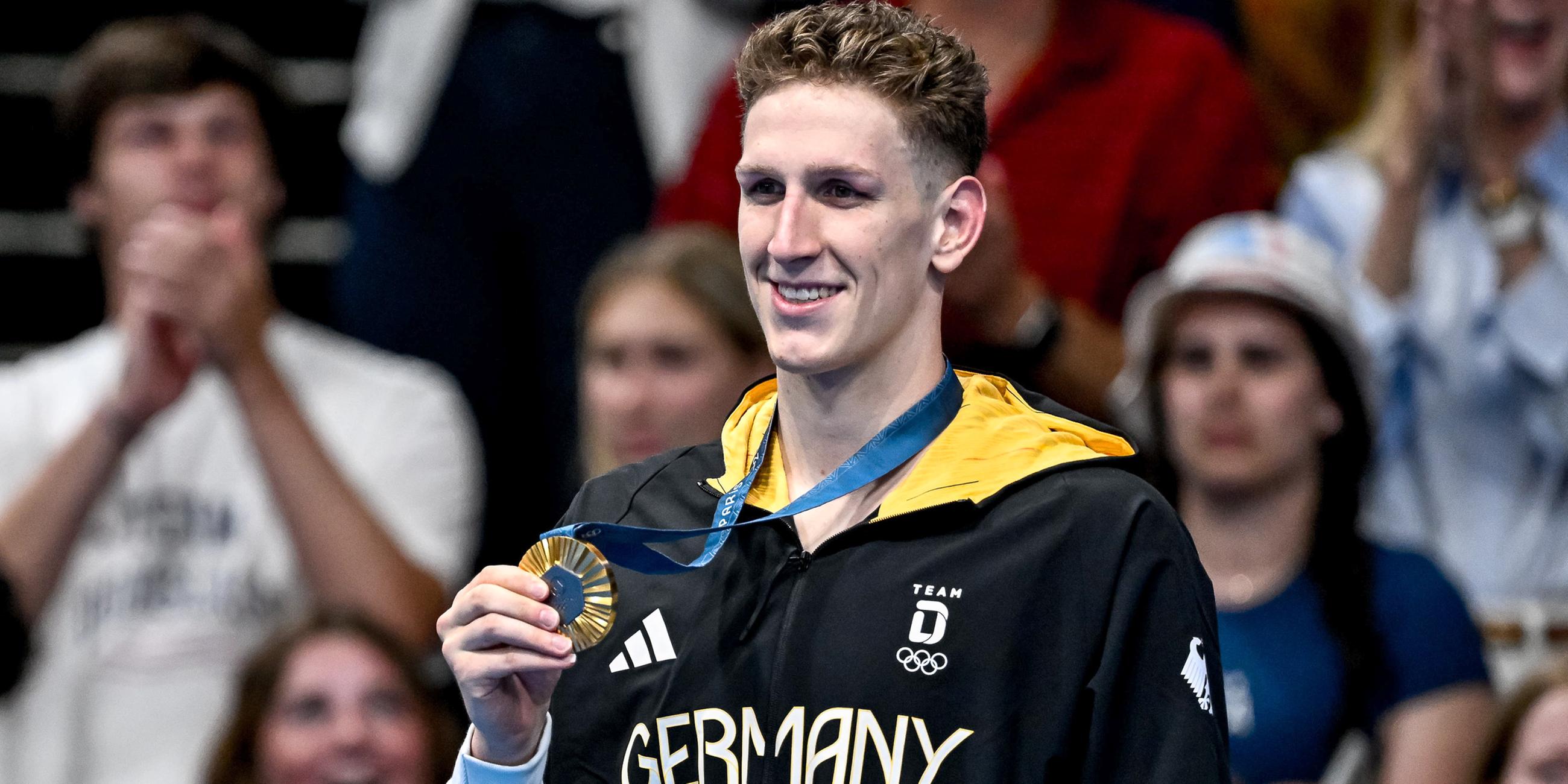 Lukas Märtens aus Deutschland zeigt die Goldmedaille nach dem 400-m-Freistil-Finale der Männer.