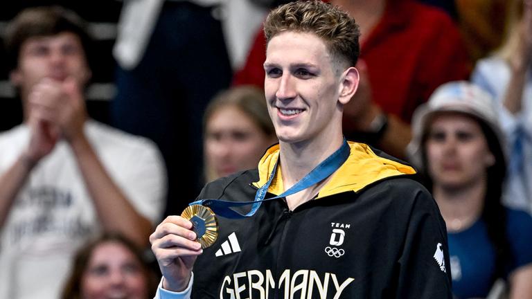 Lukas Märtens aus Deutschland zeigt die Goldmedaille nach dem 400-m-Freistil-Finale der Männer.