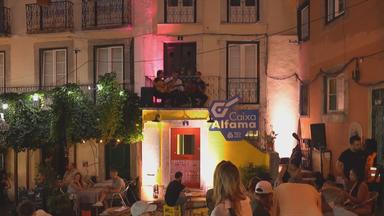 Drei Männer mit Gitarren auf einem Balkon in der Altstadt von Lissabon