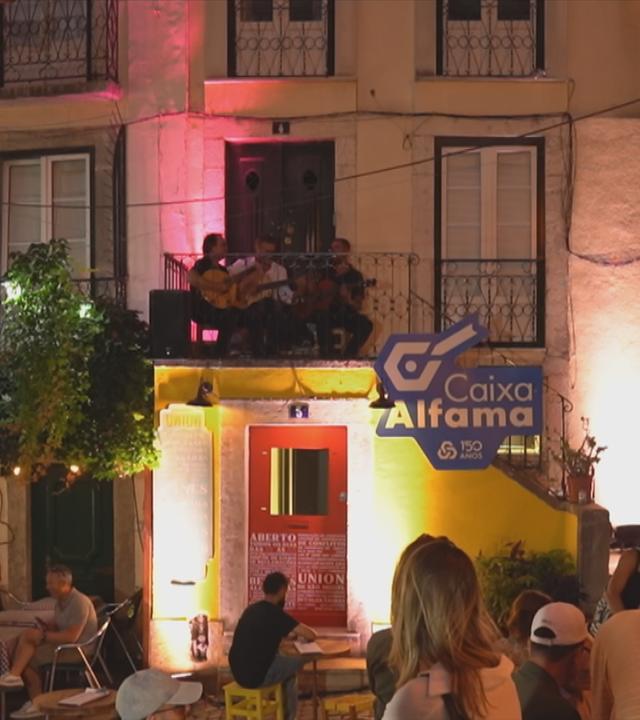 Drei Männer mit Gitarren auf einem Balkon in der Altstadt von Lissabon