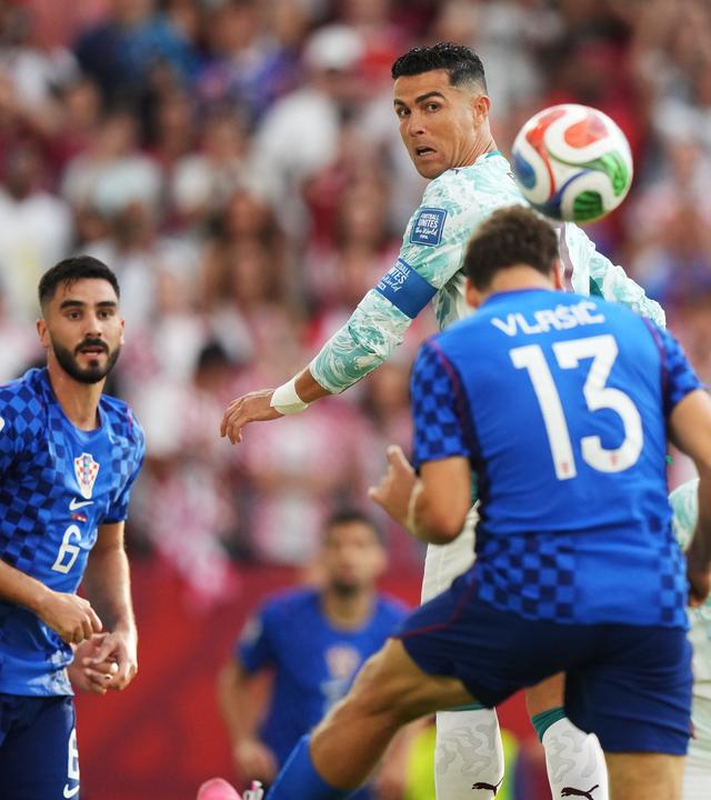 Portugals Cristiano Ronaldo beobachtet im Sprung, wie Nikola Vlasic den Ball aus der Gefahrenzone köpft.
