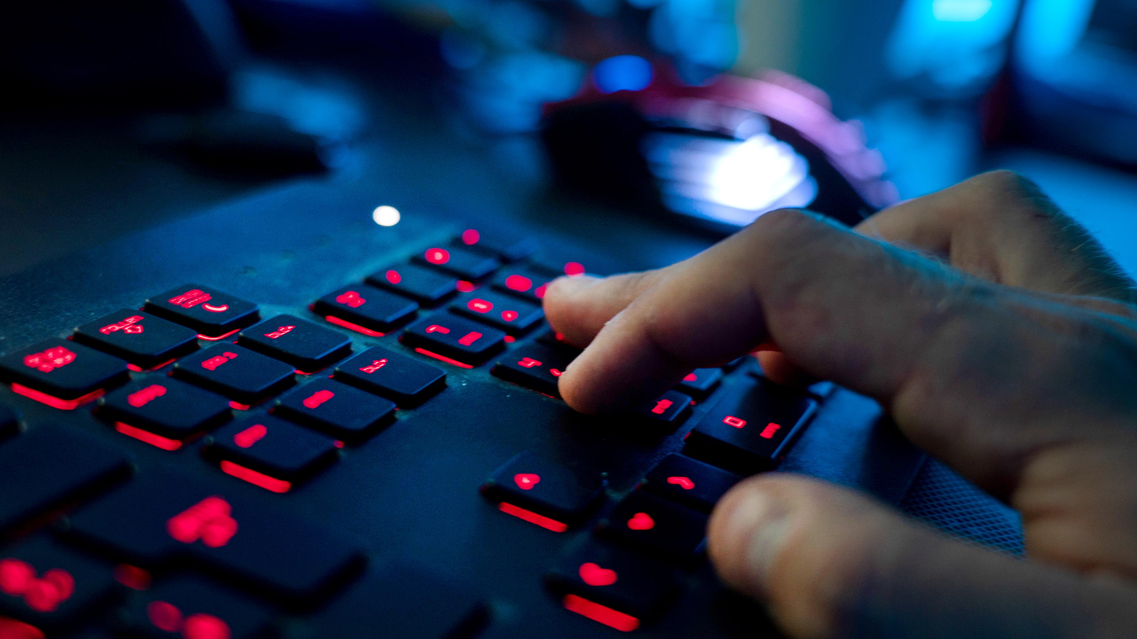 Ein Mann sitzt am Rechner und tippt auf einer Tastatur.