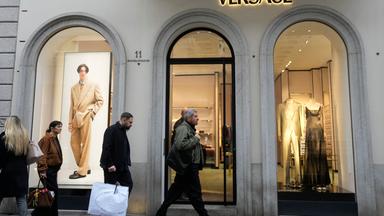 Passanten laufen an einer Versace-Filiale vorbei.