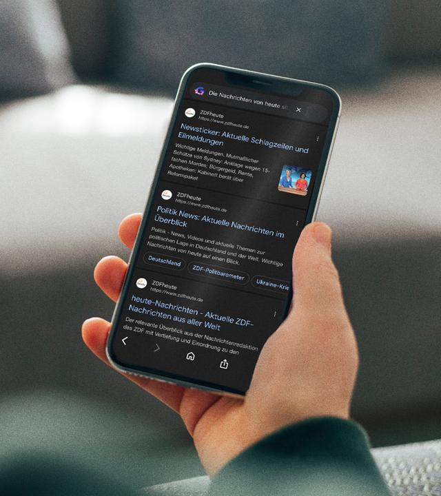 Eine Person hält ein Smartphone in der Hand. Darauf ist die ZDFheute bei Google zu sehen. Symbolbild.
