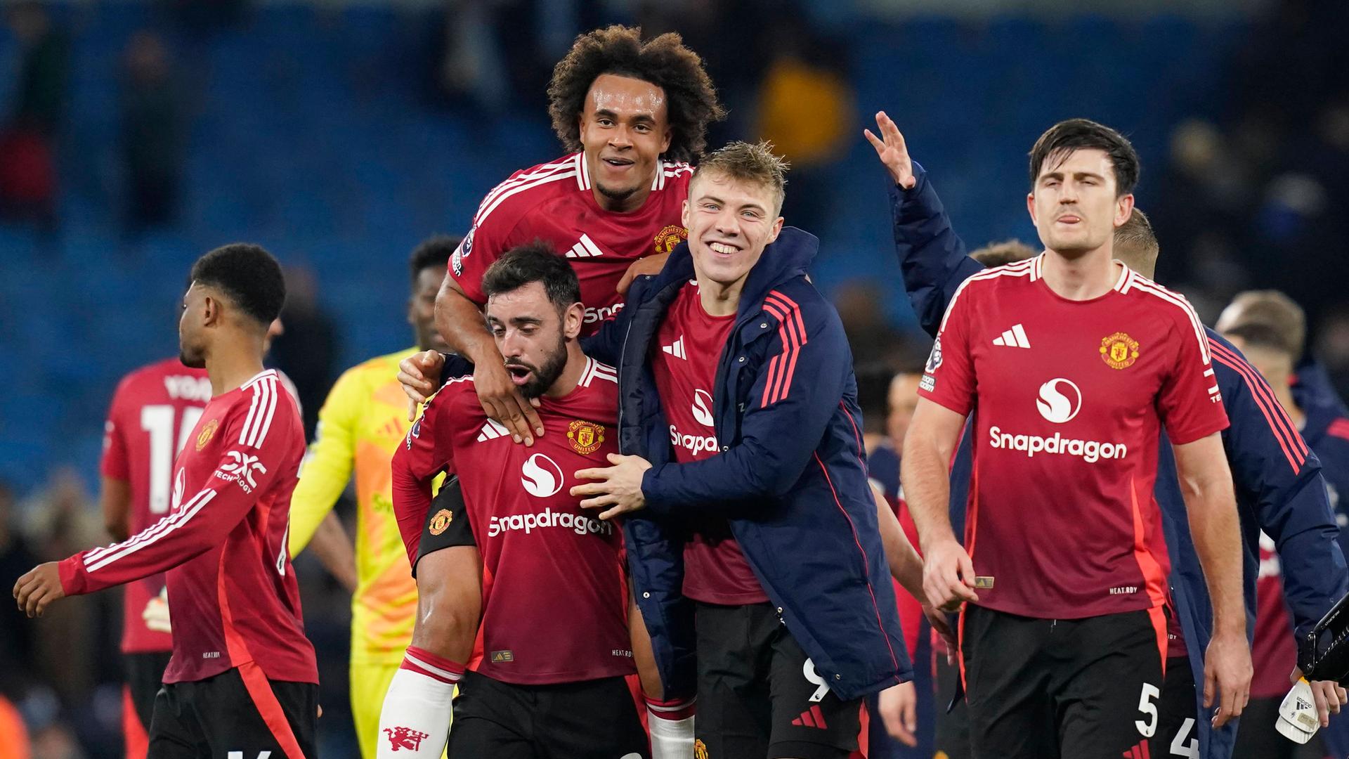 Bruno Fernandes, Joshua Zirkzee und Rasmus Hojlund von Manchester United bejubeln ihren Sieg gegen Manchester CIty.