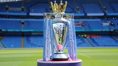 Der Sigerpokal der englischen Liga Premier League von 2018 steht auf einem Podest vor einem leeren Stadion.